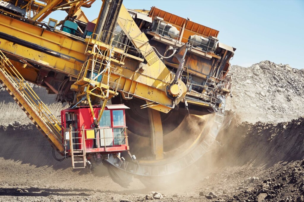 A large excavator is working on a large pile of dirt.